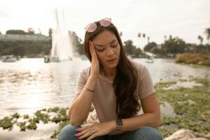 femme fatiguée à l'extérieur se tenant l atête