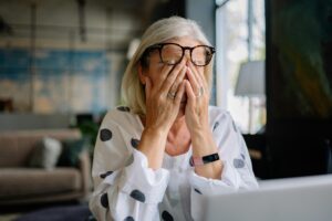 femme fatiguée par la ménopause se tenant la tête à deux mains