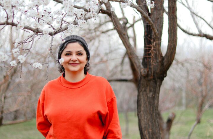 préparer son corps à la ménopause femme en chemise orange en pleine nature – vitalité et ménopause
